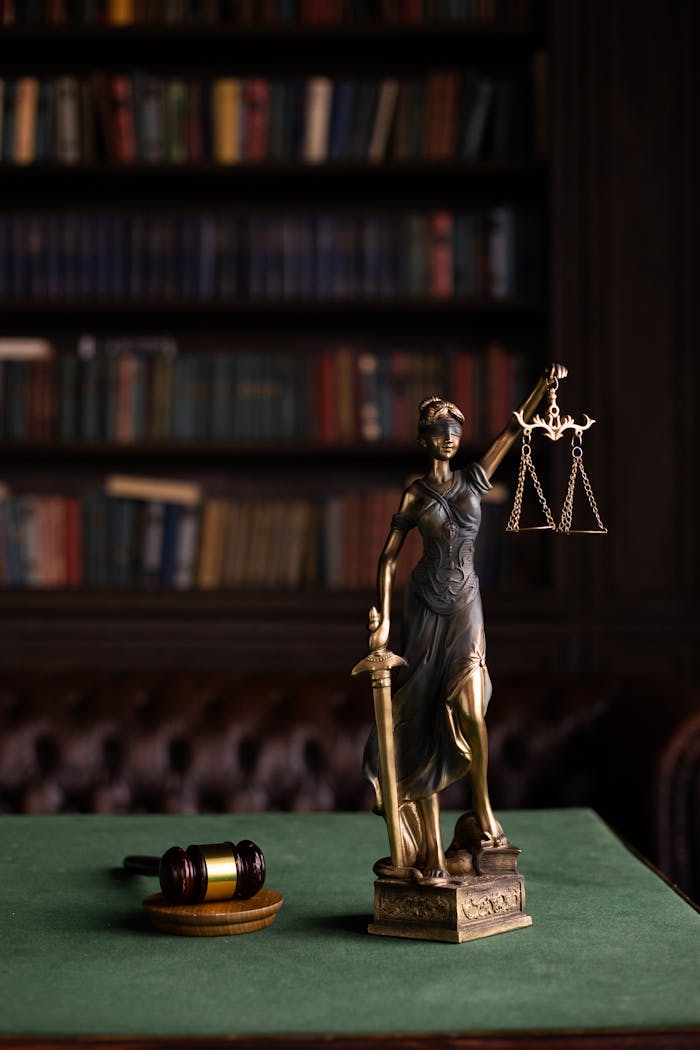 Services-01 Lady Justice and gavel on a table in a classic law library setting.